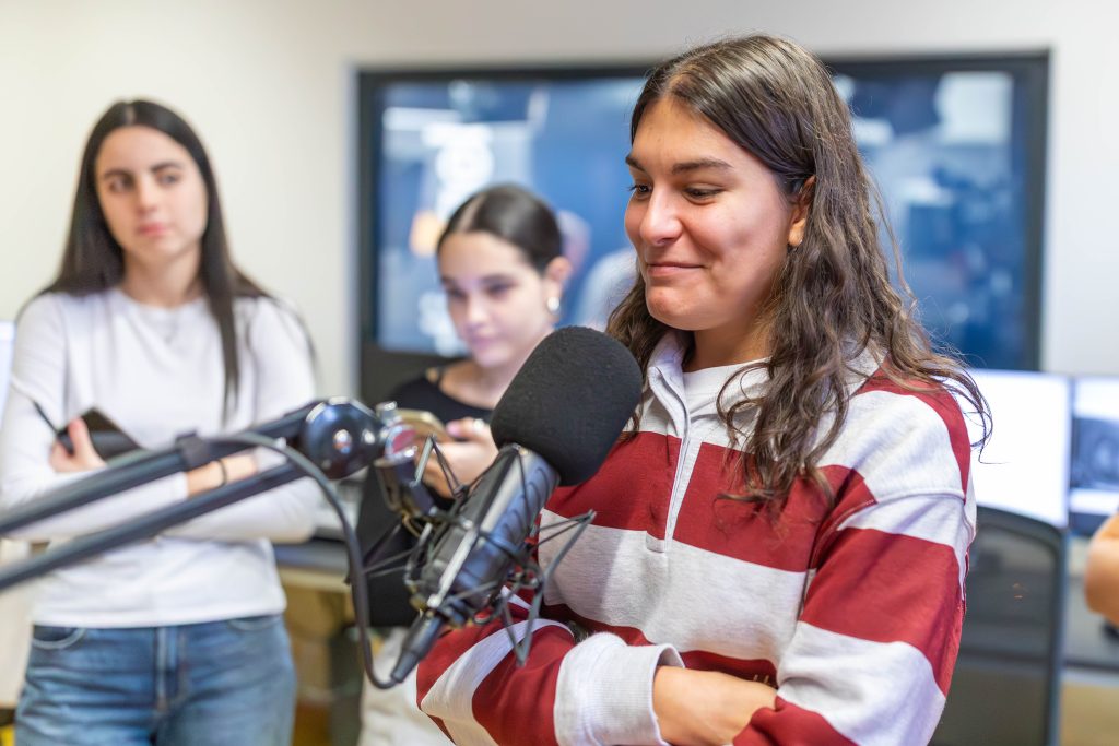 Gruppe von jungen Frauen steht in einem Raum mit gelbem Boden vor einem Fenster