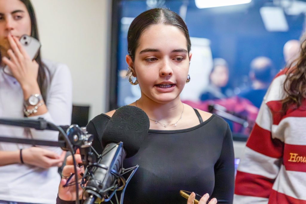 Gruppe von jungen Frauen steht in einem Raum mit gelbem Boden vor einem Fenster
