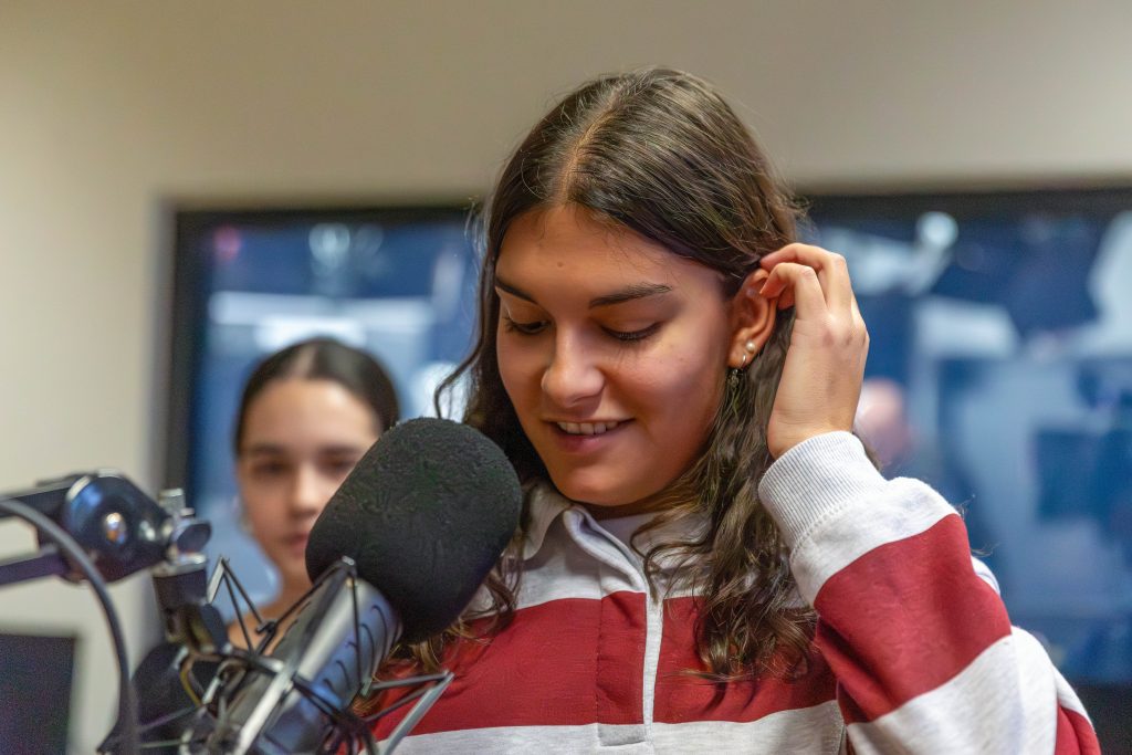 junge Fraue steht in einem Raum mit gelbem Boden vor einem Fenster