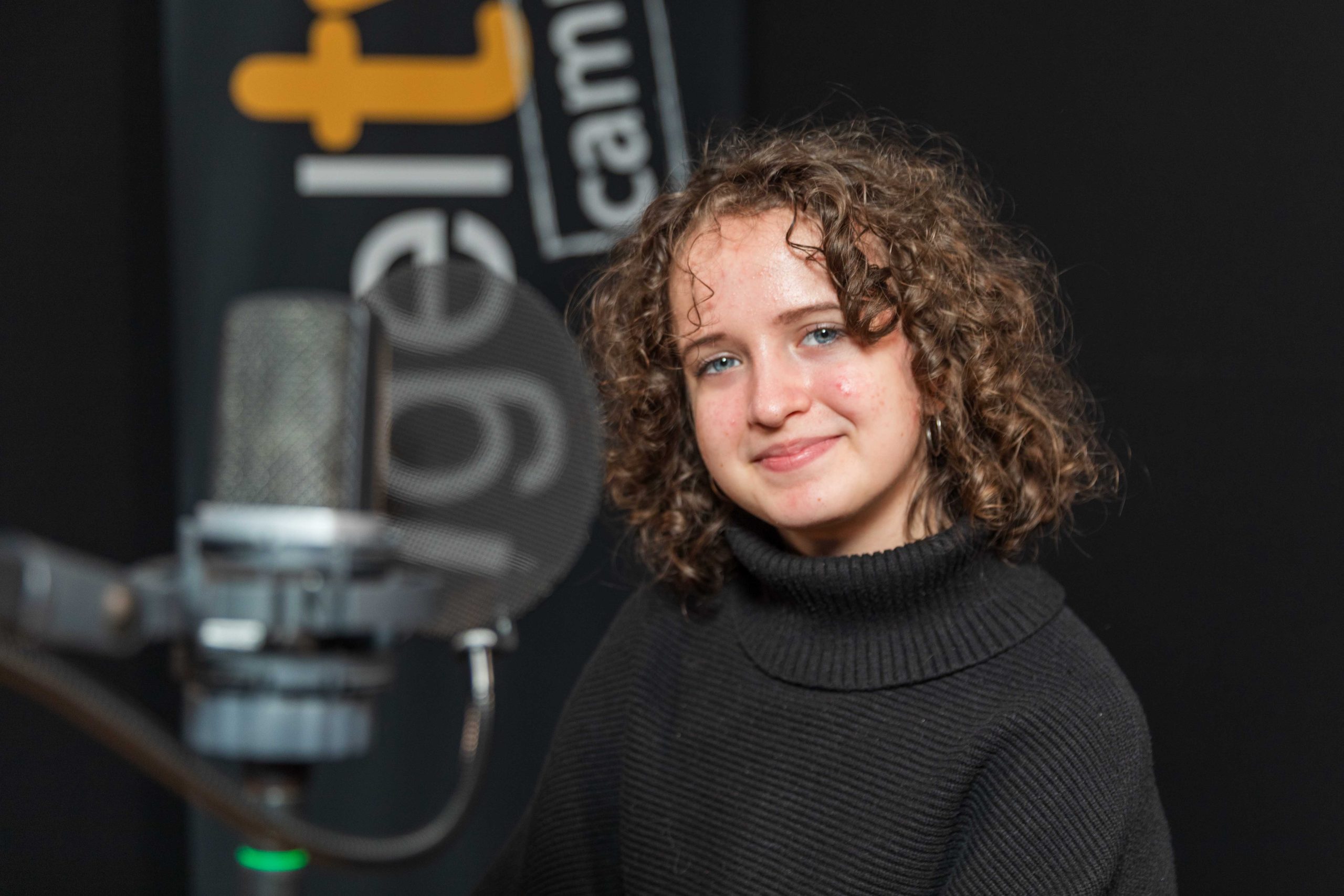 kind vor einem Mikrofon in einem Radiostudio