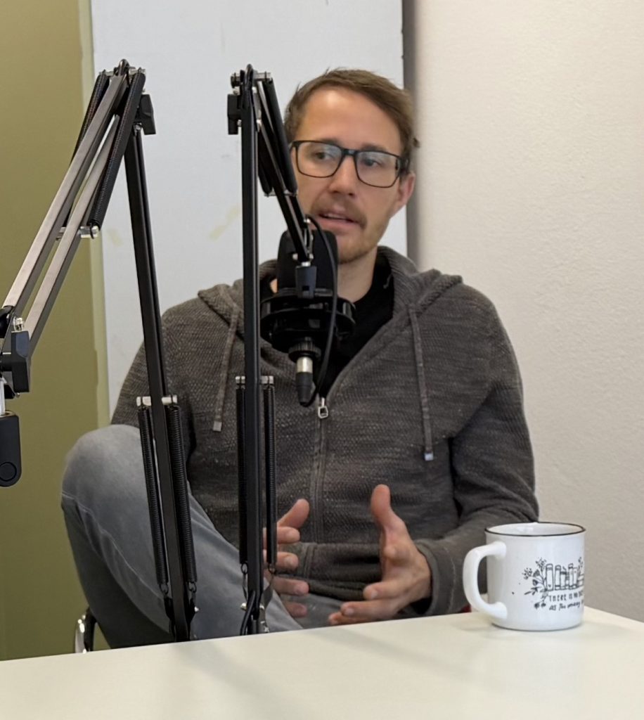 Mann mit Brille vor einem Mikrofon