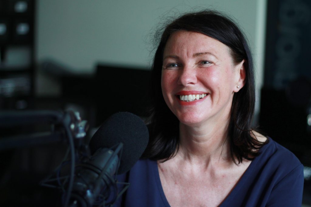 Frau mit Mikrofon im Studio.